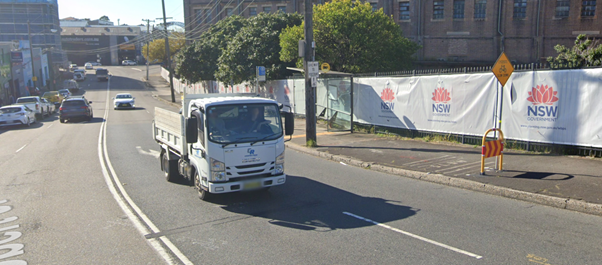 A truck driving down the street

Description automatically generated