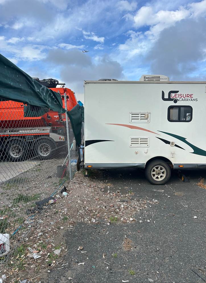 A trailer parked next to a fence

AI-generated content may be incorrect.